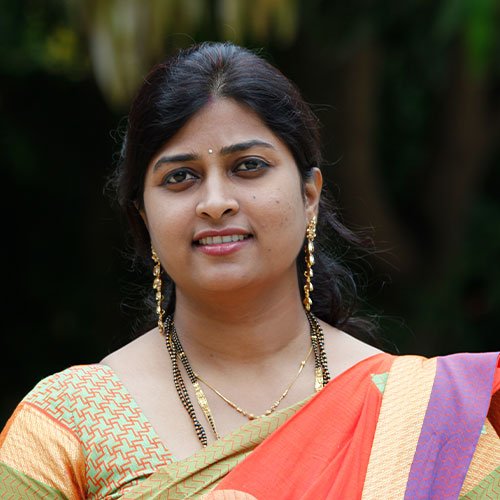 A smiling woman in a traditional attire, representing Madhumathi's vibrant culture and beauty.