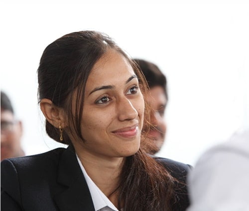 A happy student from ABBSSM, holding books and smiling